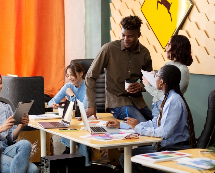 A group of professionals working at a table with laptops in a modern Rankupper office environment. Featured on the Rankupper.