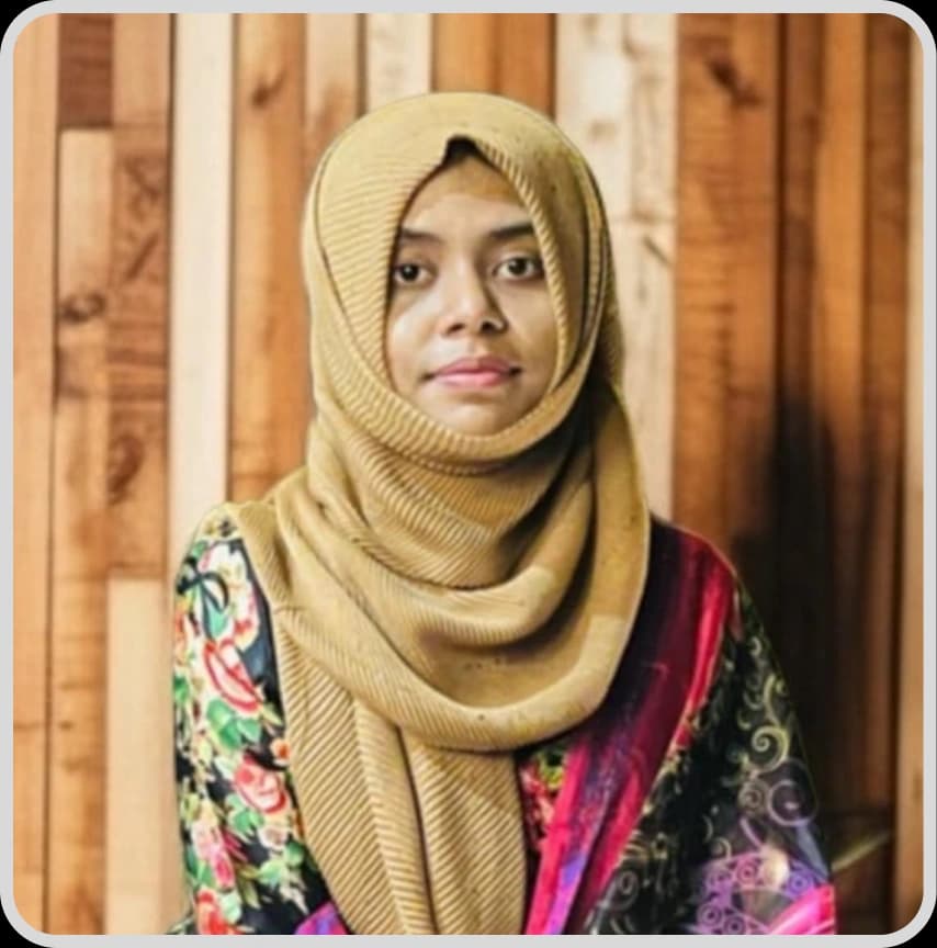 A woman in a blue shirt stands with arms crossed, representing Farzana Akter Riya, Business Development Executive at Rankupper.