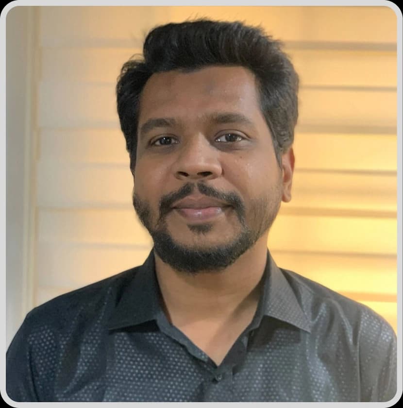 A man in glasses and a suit stands with arms crossed, representing SEO Specialist Masum Hossain Rankupper.