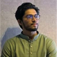 A man in a blue shirt stands with arms crossed, representing Md. Nafees Ashker, Software developer at Rankupper.