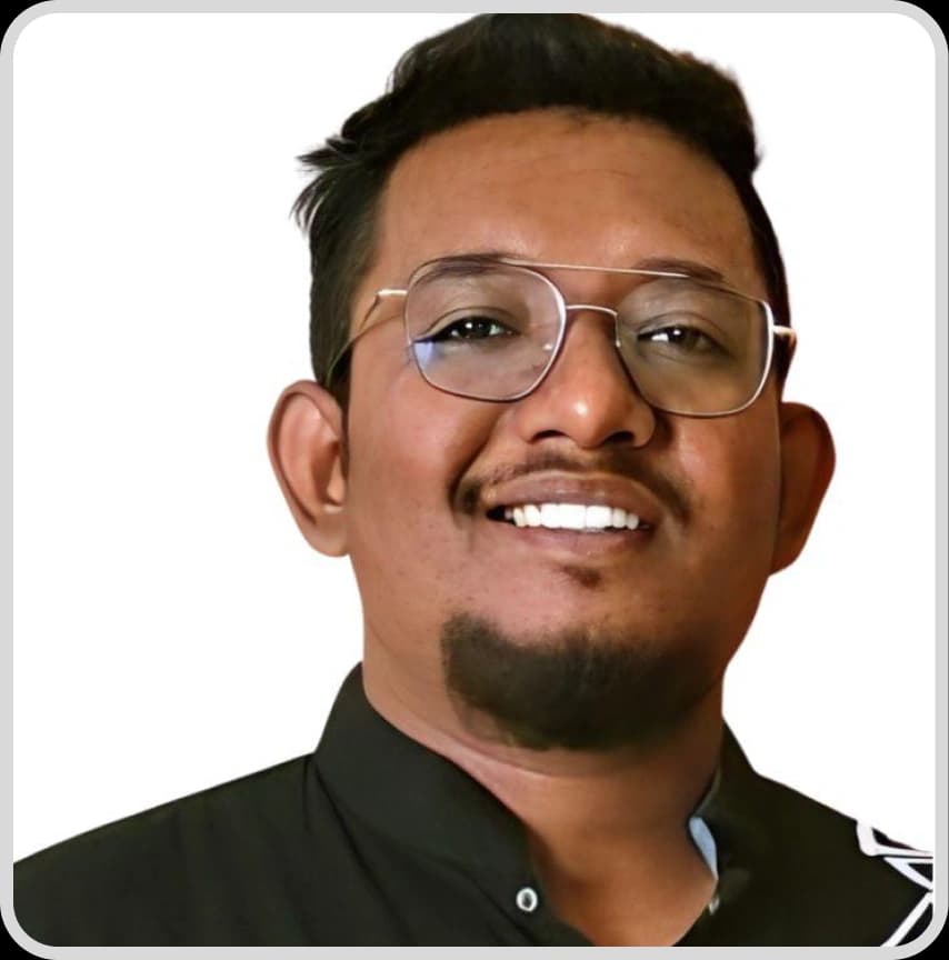 A man in a blue shirt stands with arms crossed, representing Sadekuzzaman Masum, Ecommerce Specialist at Rankupper.